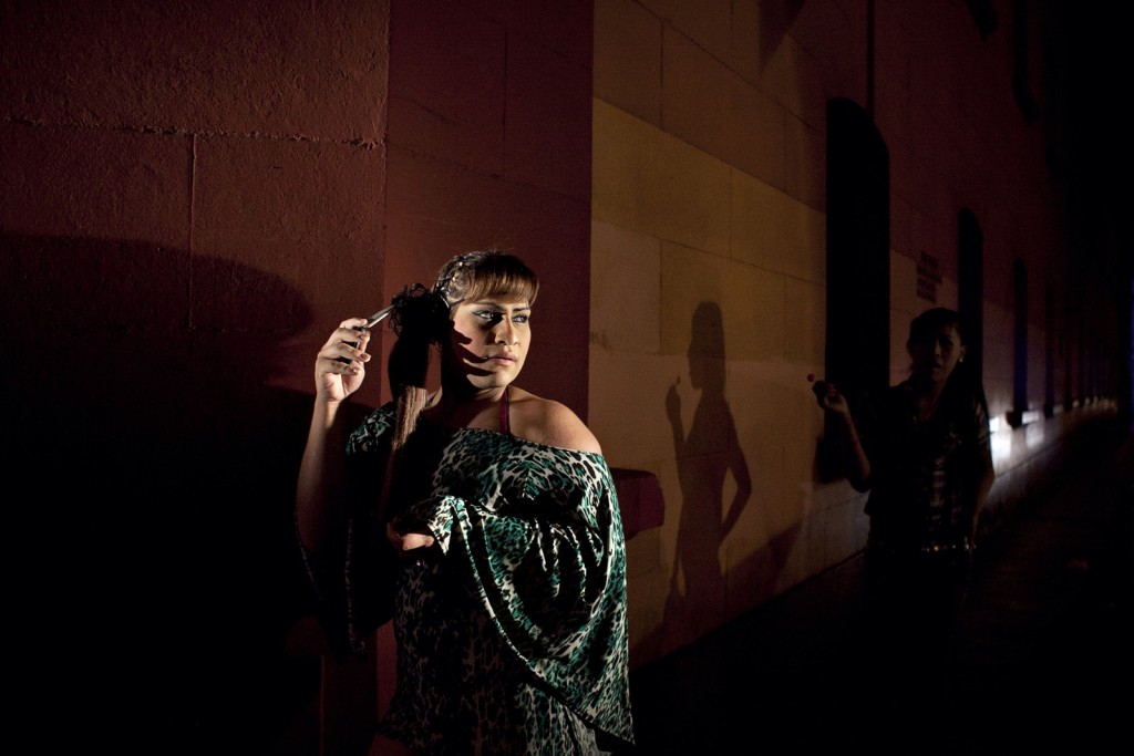 Asumi (left) and Oriana stand in the light of a police car during a nightly raid. "There's lots of physical and verbal abuse, and the police will break into the women's homes and arrest all of the women in the house,” says photographer Danielle Villasana. "There are some accounts of police arresting transwomen who aren't even working, they just arrest them for being transgender. A woman might be running to get food during a police raid, in her pajamas and not in her work clothes, but she will still get arrested.” Photo by Danielle Villasana 