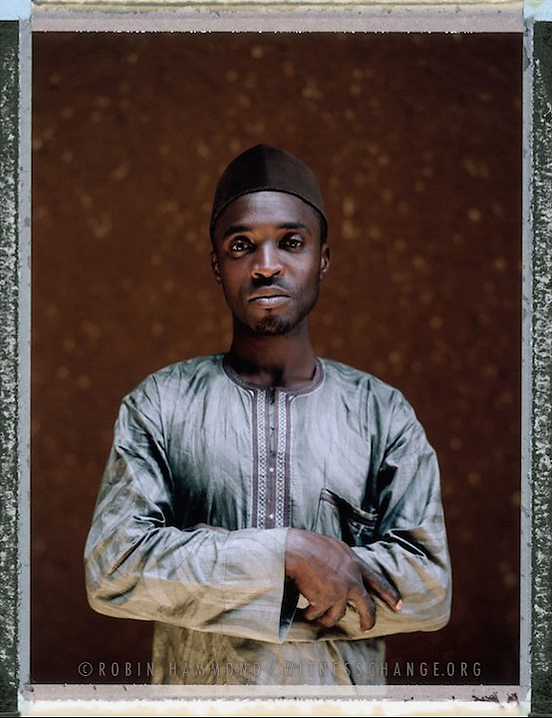 A posed posed portrait of Ibrahim (not his real name) who says he has been imprisoned and tortured because of his sexual orientation – he is Gay. He does his best to support other young gay men who have suffered persecution through his small group Hope Alive Intiative. Since Nigeria’s president signed a harsh law criminalizing homosexuality throughout the country last month, arrests of gay people have multiplied, advocates have been forced to go underground, some people fearful of the law have sought asylum overseas and news media demands for a crackdown have flourished. Three young men were recently flogged 20 times in a northern Nigerian court room for being gay. Some consider them lucky. The penalty for gay sex under local Islamic law is death by stoning. Nigeria, April 2014. Photo Robin Hammond  While many countries around the world are legally recognizing same-sex relationships, individuals in nearly 80 countries face criminal sanctions for private consensual relations with another adult of the same sex. Violence and discrimination based on sexual orientation or gender expression is even more widespread. Africa is becoming the worst continent for Lesbian, Gay, Bi-sexual, Transgender, Queer, Inter-sex (LGBTQI) individuals. More than two thirds of African countries have laws criminalizing consensual same-sex acts. In some, homosexuality is punishable by death. In Nigeria new homophobic laws introduced in 2013 led to dramatic increase in attacks. Under Sharia Law, homosexuality is punishable by death, up to 50 lashes and six months in prison for woman; for men elsewhere, up to 14 years in prison. Same sex acts are illegal in Uganda. A discriminatory law was passed then struck down and homophobic attacks rose tenfold after the passage of the Anti-Homosexuality Act. In Cameroon it is also illegal. More cases against suspected homosexuals are brought here than any other African country. In stark contrast with the rest of the continent, same sex relationships are legal in South Africa. The country has the most liberal laws toward gays and lesbians on the continent, with a constitution guaranteeing LBGTQI rights. Because of this, LGBTQI Africans from all over the continent fleeing persecution have come to South Africa. Despite these laws, many lesbians have been victims of ‘corrective rape’ and homosexuals have been murdered for their sexuality. Homophobia is by no means just an African problem. In Russia, politicians spread intolerance. In June 2013 the country passed a law making “propaganda” about “non-traditional sexual relationships” a crime. Attacks against gays rose. Videos of gay men being tortured have been posted online. In predominantly Muslim Malaysia, law currently provides for whipping and up to a 20-year prison sentence for homosexual acts involving either men or women. Increased extreme Islamification in the Middle East is making life more dangerous for gay men there, as evidenced by ISIS’s recent murders of homosexual men. While homophobic discrimination is widespread in Lebanon, life is much safer there than Iran, Iraq, and Syria from which refugees are fleeing due to homophobic persecution. Photo Robin Hammond/Panos for Witness Change
