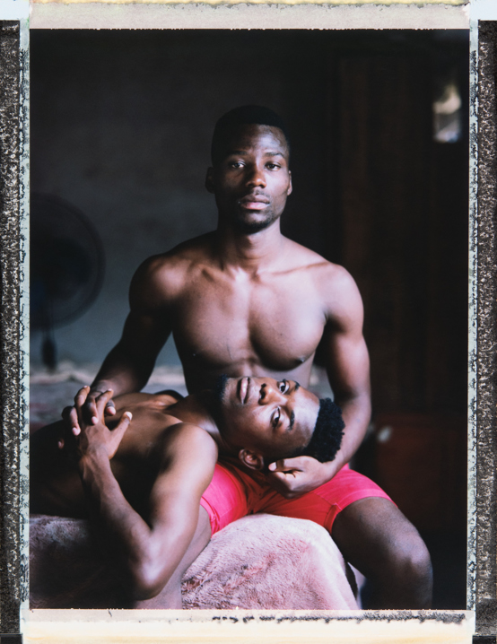 23 year old Avelino (sitting) & 25 year old Neston (lying) are a gay couple. Neston’s family did not approve of his homosexuality. Avelino, byt contrast, when he cam out to his mother, she accepted him. Avelino recalls when Neston had a fight with his family, “‘Why don't you come and live with me,” Avelino said, “let's live together in my house’ and he asked ‘Are you serious?’ and, because of what my mother had told me before, I said ‘Yes’.” Avelino’s mother welcomed Neston, but his father did not know about his son’s sexuality at the time: “It was a huge shock when he found out, we had already been going out for about 6 months when he (his father) found out exactly what we meant to each other. It was such a big shock that we spent about 2 days out in the street… The whole family here had a meeting, in a weird way, a big confusion and everyone, brothers, nephews, everyone revolted against my father ‘He is everything, he works hard in school, he works hard in athletics... What difference does it make?’ I still get emotional when I remember that my father sat with us, apologized and asked him [Neston] to live with us.” But not everyone has been so accepting. When a photo of Avelino and Neston kissing was posted on facebook, Avelino, an international track athlete, lost his spot on the team: “They were made aware of my sexual orientation, they stopped summoning me for international competitions… To let go of the Mozambican Athletics Federation in order to live what I am, who we are... I do not regret anything, if I had to go back in time and do something different, I would not do anything different, I would do everything the same.” Maputo, Mozambique. 22 February, 2018. Photo Robin Hammond/Witness Change